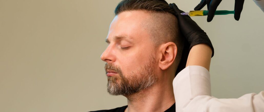 Ein Mann sitzt mit geschlossenen Augen, während eine medizinische Fachkraft mit Handschuhen eine Injektion in die Kopfhaut setzt.