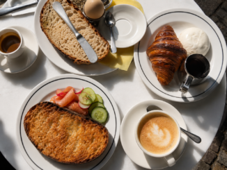 Frühstückstisch mit Croissant, Brot, Ei, Lachs, Gurken, Kaffee und weiteren Speisen als Beispiel für All you can eat in Berlin.