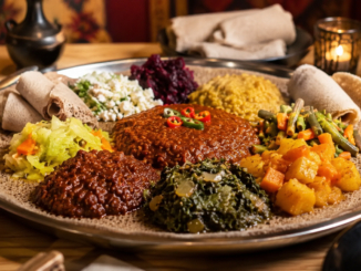 Äthiopische Spezialitäten mit Injera, würzigen Eintöpfen und Gemüse auf einer großen Servierplatte