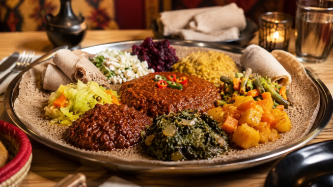 Äthiopische Spezialitäten mit Injera, würzigen Eintöpfen und Gemüse auf einer großen Servierplatte