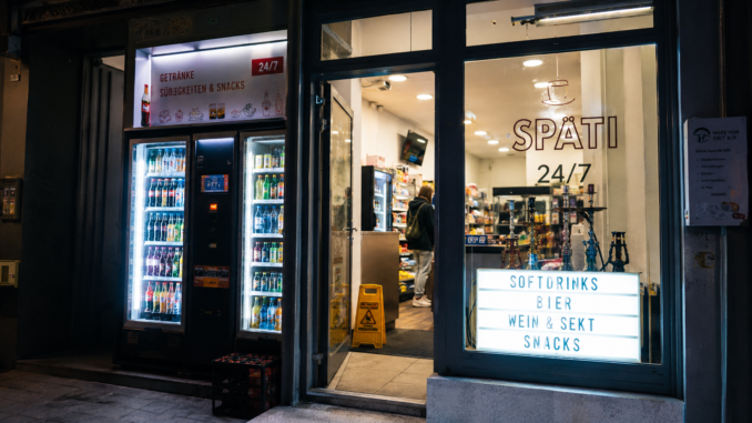 Beleuchteter 24/7-Späti mit Getränkeautomaten und Snacks in Wien bei Nacht