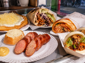 Auswahl an Wiener Streetfood mit Käsekrainer, Langos, Döner, Wrap und Bao Buns auf einem Imbissstand