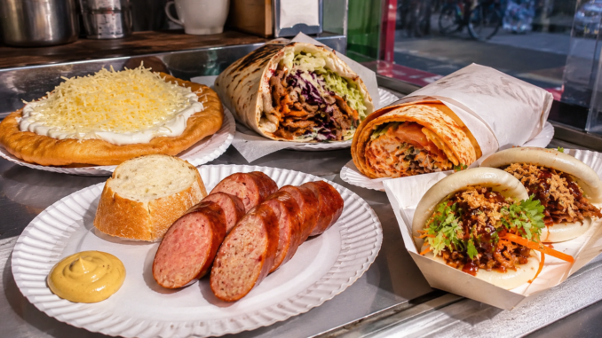 Auswahl an Wiener Streetfood mit Käsekrainer, Langos, Döner, Wrap und Bao Buns auf einem Imbissstand