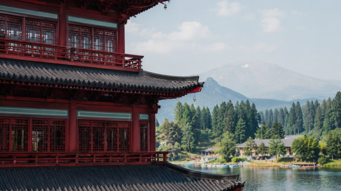 Wellnesshotel in Österreich mit asiatisch inspirierter Architektur, See und Berglandschaft im Hintergrund.