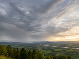 Dichte Wolken und Regen ziehen über eine Landschaft, während sich der Himmel langsam aufhellt
