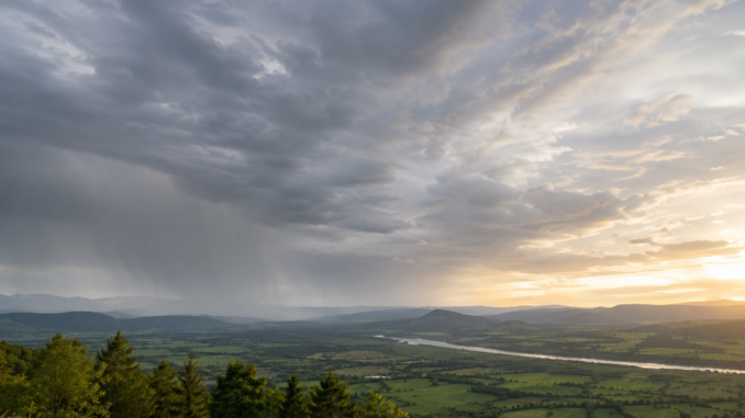 Dichte Wolken und Regen ziehen über eine Landschaft, während sich der Himmel langsam aufhellt