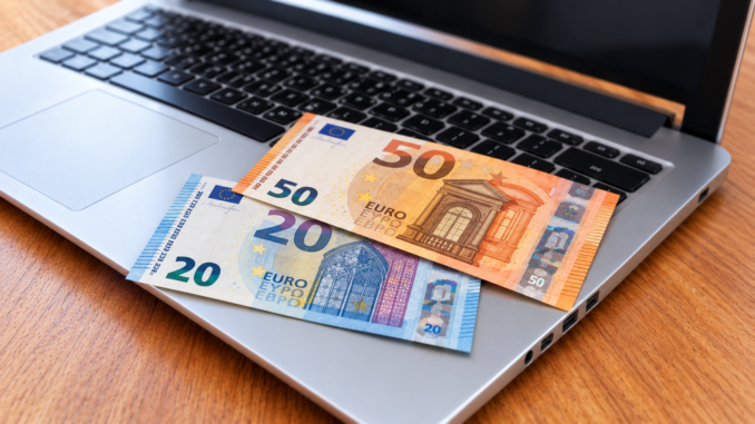 Zwei Euro-Scheine auf silbernem Laptop